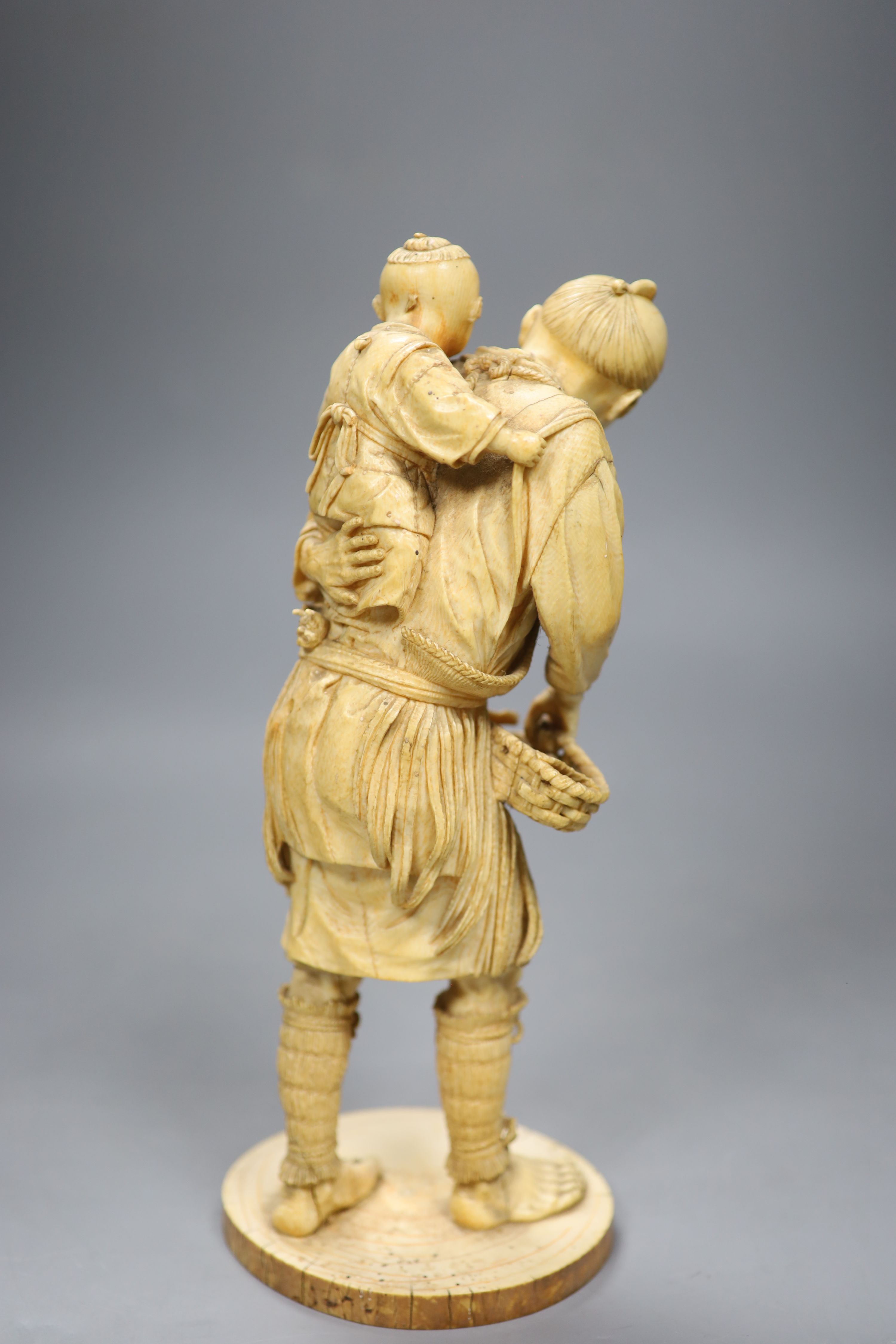 A large Japanese sectional ivory okimono of a fisherman and a boy, Meiji period, height 26cm